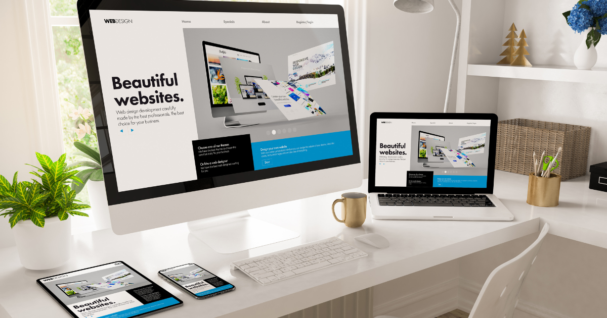 O mesmo site responsivo exibido em um desktop, notebook, tablet e celular sobre uma mesa